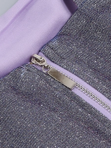Detailed macro view of purple shimmering fabric featuring a sleek silver metal zipper closure