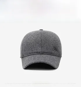Detail of grey knitted baseball cap with fleece lining and small metal side logo