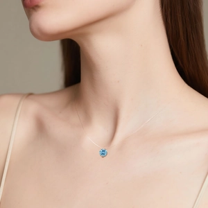 Close-up of a 2-carat blue sapphire pendant on a transparent invisible fishing line necklace