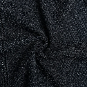 Macro shot of black glitter knit fabric showing textured weave and shimmering details