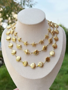 Detail showing 18k gold plated shell and starfish necklace layers