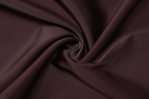 Close-up of luxurious dark brown silk satin fabric with elegant drape and high luster finish