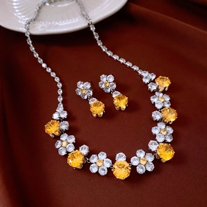 Macro shot of vintage floral jewelry set with yellow zircon on elegant silk background