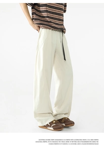 Detalle de pantalones casuales crema de pierna ancha con cintura elástica y cordón negro