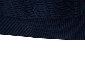 Detailed view of the dark blue ribbed cuff and fine knit texture of the men's sweater