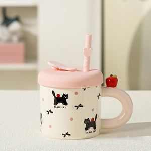 Detail view of the cat ceramic mug showing the pink silicone lid and matching straw