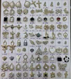 DIY jewelry parts collection featuring heart pendants and pearls with handwritten codes
