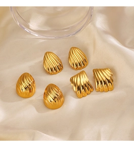 Detailed shot of gold-plated geometric ribbed earrings on elegant white silk fabric