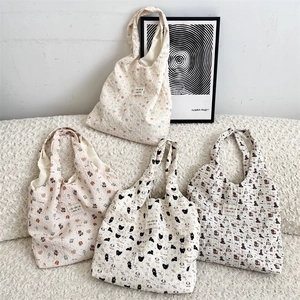 Dettaglio di borse tote in tessuto goffrato con diverse stampe di cartoni animati