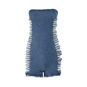 Détail d'une combinaison en jean bleu avec découpes latérales et franges effilochées