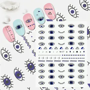 Detailed view of evil eye nail stickers with blue geometric patterns and artistic samples