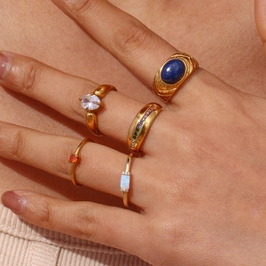 Close-up of five 18K gold plated stainless steel rings featuring colorful gemstones