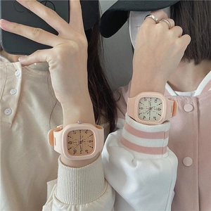 Close-up of a pair of matching pink silicone square sport watches worn on wrists
