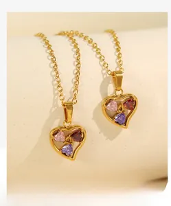 Detail of 18k gold plated necklace with hollow heart pendant and colorful zircons