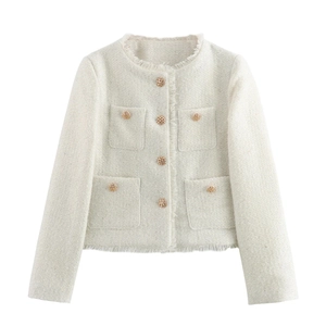 Close-up of cream tweed jacket featuring gold hollow buttons and fringed trim detail