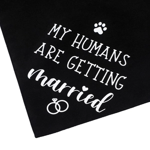 Detail of black pet bandana with white My Humans Are Getting Married text and paw icons