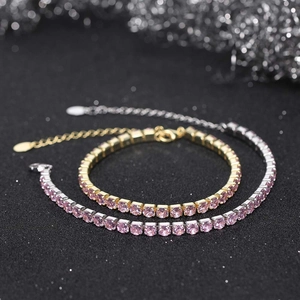 Detailed close-up of gold and silver tennis bracelets with pink round cubic zirconia stones