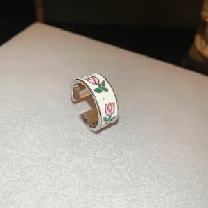 Silver wide open ring featuring white enamel finish with pink tulip flower patterns