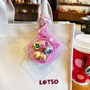Pink cartoon water machine keychain with cute dolls on a beige canvas bag