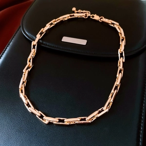 Detail of adjustable gold alloy chain necklace with rectangle links on black leather