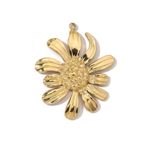 Macro view of a gold-toned flower charm in titanium steel with detailed petal textures