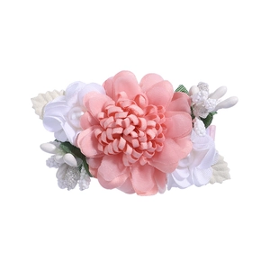 Detailed view of pink fabric flower hair clip with pearls and elegant rhinestone accents
