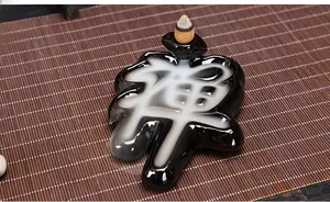 Macro view of Zen character ceramic backflow incense burner with smoke flowing through grooves