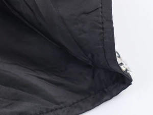 Close-up of black tweed fabric texture and stitching details for women sleeveless dress
