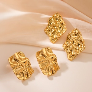 Irregular textured geometric 18K gold plated stud earrings on soft pink silk fabric