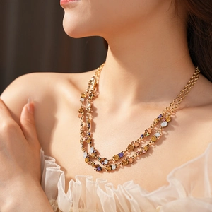 Detail of layered gold necklace with colorful rhinestones on a model neck