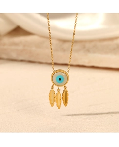 Detail view of evil eye necklace with three golden leaf pendants on stone background