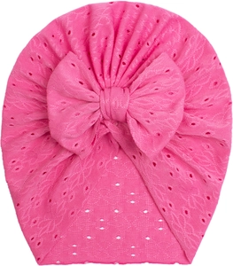 Close-up of bright pink baby turban hat featuring mesh lace texture and large bow detail