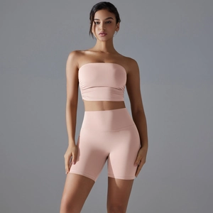 Detail of high-waist stretch gym shorts and pink sports bra yoga set on model