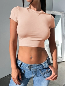Close-up of a slim-fit nude pink crop top with a Y2K style paired with low-rise jeans