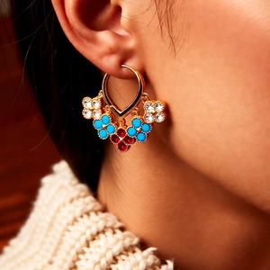 Detail of 18K gold plated vintage earrings with multicolor clover flower tassels on model