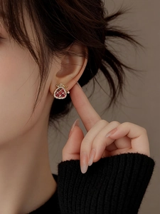 Close-up of gold-plated pearl lucky bag earrings with zircon inlays worn by a model