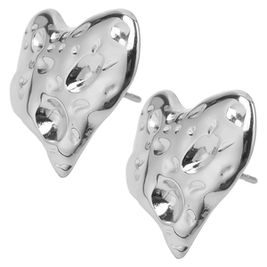 Detail of silver heart-shaped stainless steel earrings with unique hammered texture