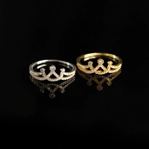 Elegant s925 silver and gold crown rings with zircons on a reflective black background