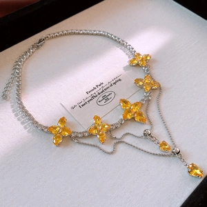 Detailed view of silver flower fringe necklace with yellow crystals and water drop pendants