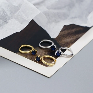 Detail of s925 silver hoop earrings with blue zircon stones in gold and silver finishes
