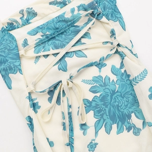 Detalle del lazo ajustable en la espalda y estampado floral azul en vestido de malla