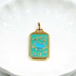 Macro view of gold-plated tarot pendant featuring teal enamel with blue heart and stars