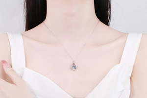 Close-up of a 1 carat teardrop moissanite necklace in s925 silver on a model neckline