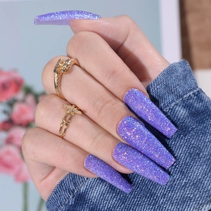 Close-up of long ballerina press-on nails with sparkling purple glitter and diamond effect