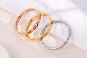 Polished stainless steel bangles in rose gold, gold, and silver on soft fur background