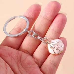 Macro shot of pink enamel shell keychain with pearl and rhinestone starfish detail