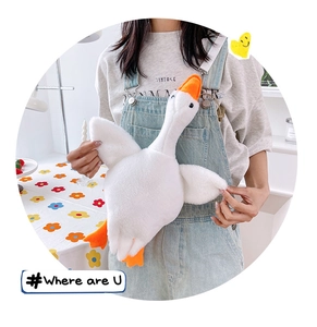 Detailed close-up of a white plush goose crossbody bag with orange beak and feet straps