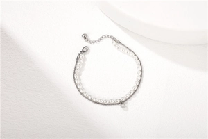 Detail of elegant double-layered bracelet with white pearls and silver metal chain