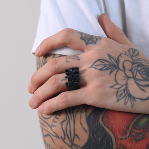 Macro shot of a black punk stainless steel ring featuring 3D embossed Fuck Off lettering