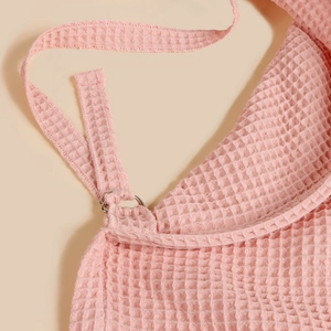 Detail of pink waffle cotton nursing cover showing premium metal D-rings and stitched edges